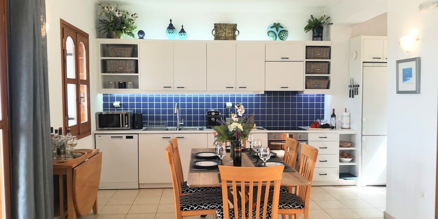 Fully equipped Villa Koumos kitchen with blue tiled splashback and dining area