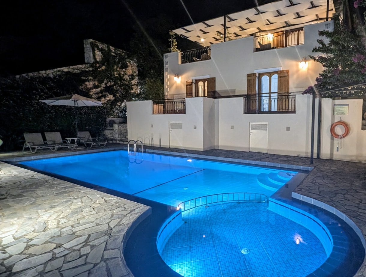 Villa Koumos illuminated at night beside the private swimming pool