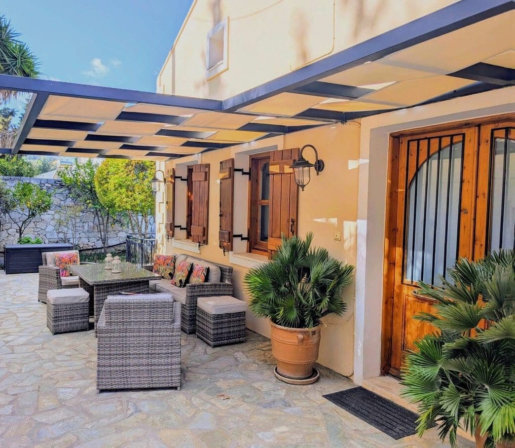 Shaded courtyard and wooden front door at Villa Koumos in Gavalochori, Crete