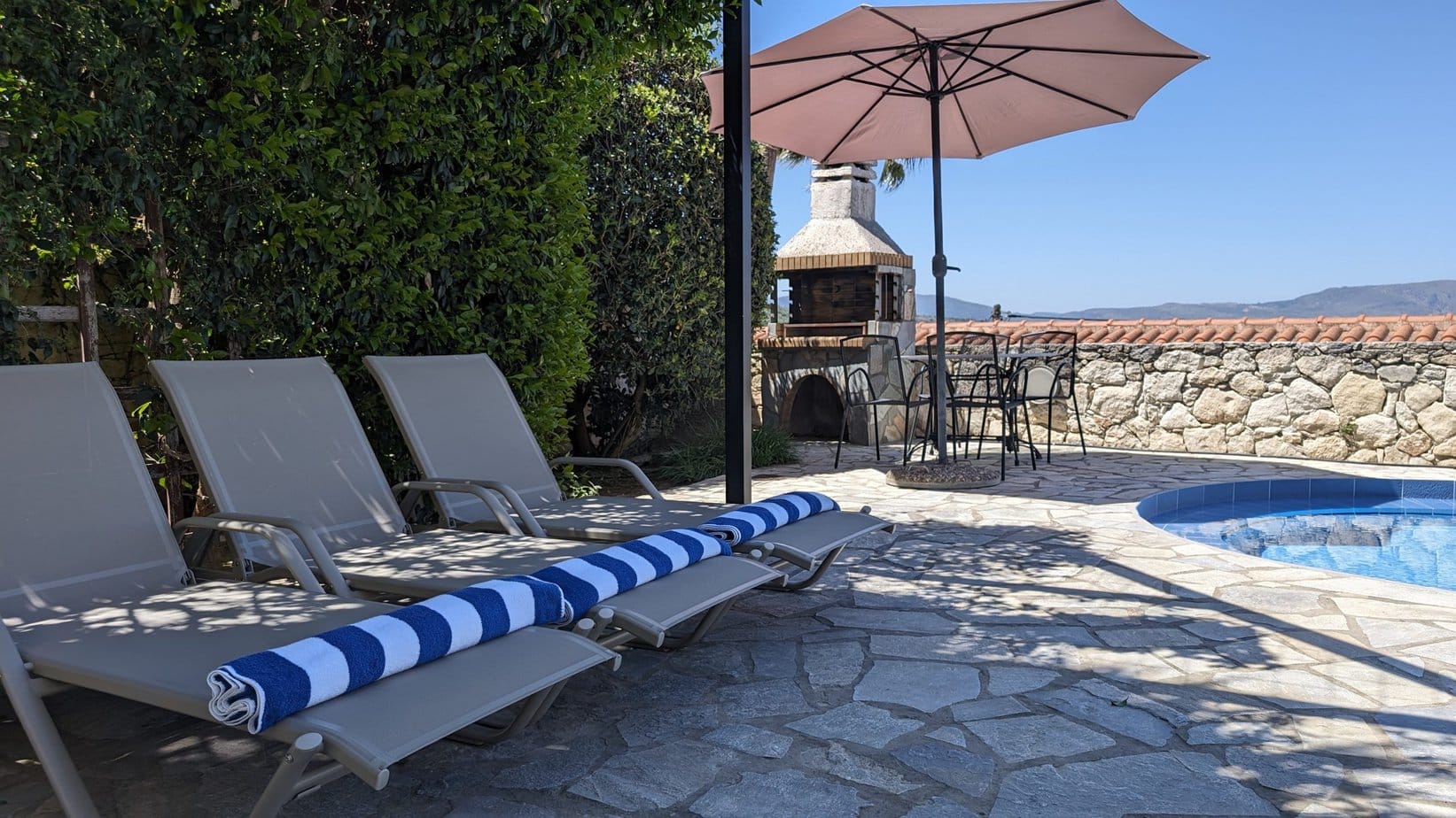 Poolside barbecue, sun loungers and pool towels at Villa Koumos
