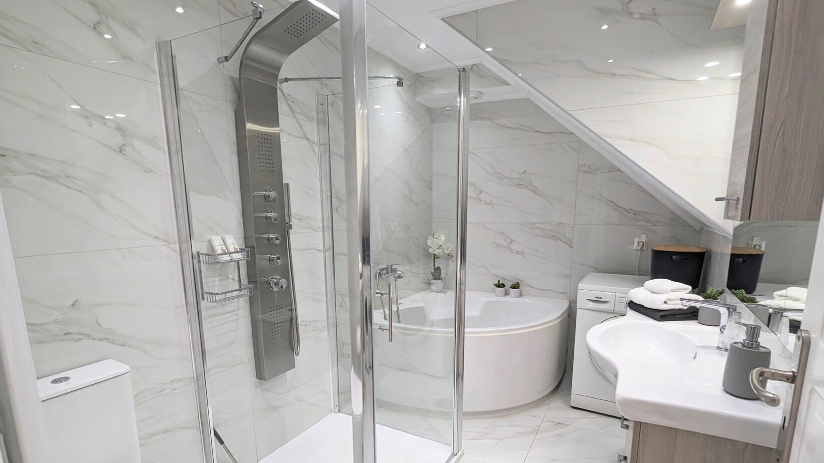 Villa Koumos family bathroom with separate shower, corner bath, basin and washing machine