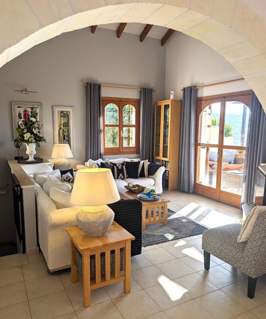 Sunlit Villa Koumos lounge with arched ceiling, comfortable seating and terrace doors