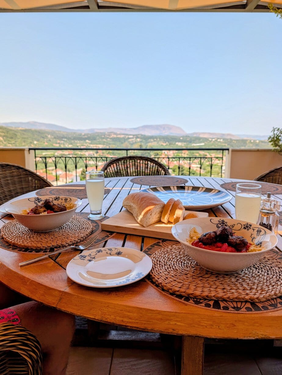 Meal served at the veranda dining table with Cretan countryside beyond